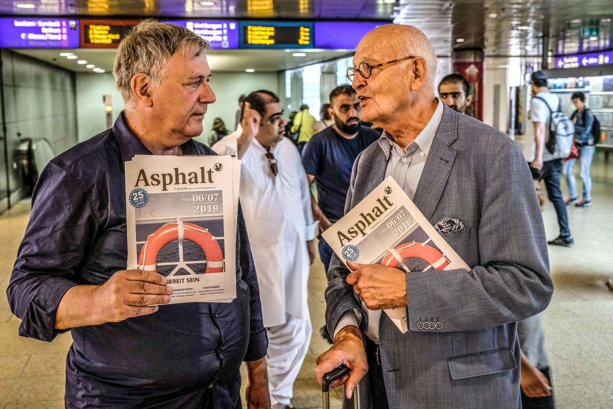 Asphalt-Verkäufer Martin Panitz (links) verkauft Herbert Schmalstieg eine Zeitung. Foto: Schulze