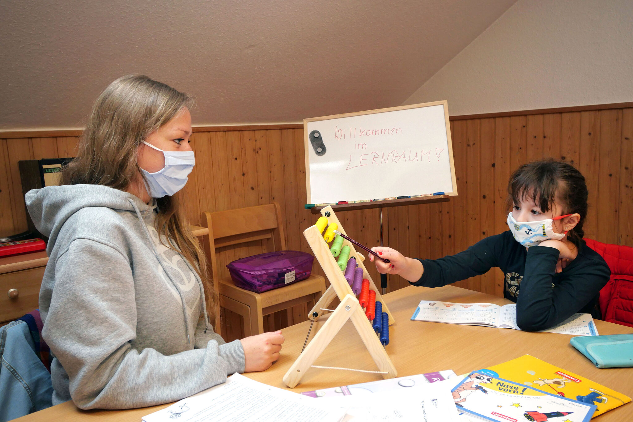 Mit Rechenschieber und Whiteboard lernt Lehramtsstudentin Katharina Korte im Haus der Paul-Gerhardt-Gemeinde in Lüneburg mit der achtjährigen Evelyn Mathe (Foto: Carolin George /epd). 