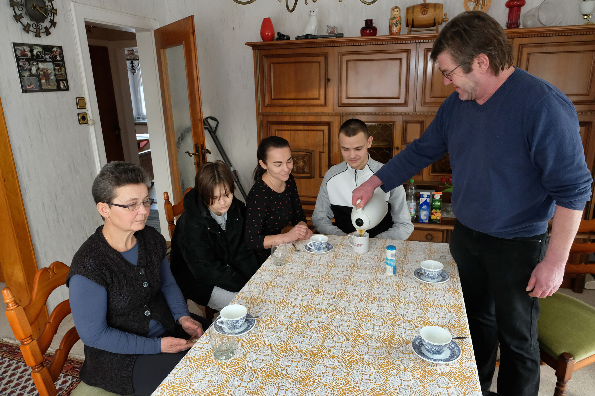 Herwig Sager (rechts) von der „Kinderhilfe Kovel“ schenkt Ljuba Semenjuk (links) und ihrer Familie Kaffee ein. Die Dolmetscherin war schon oft bei ihm zu Gast – allerdings nicht als Kriegsflüchtling. epd-Bild: Harald Koch