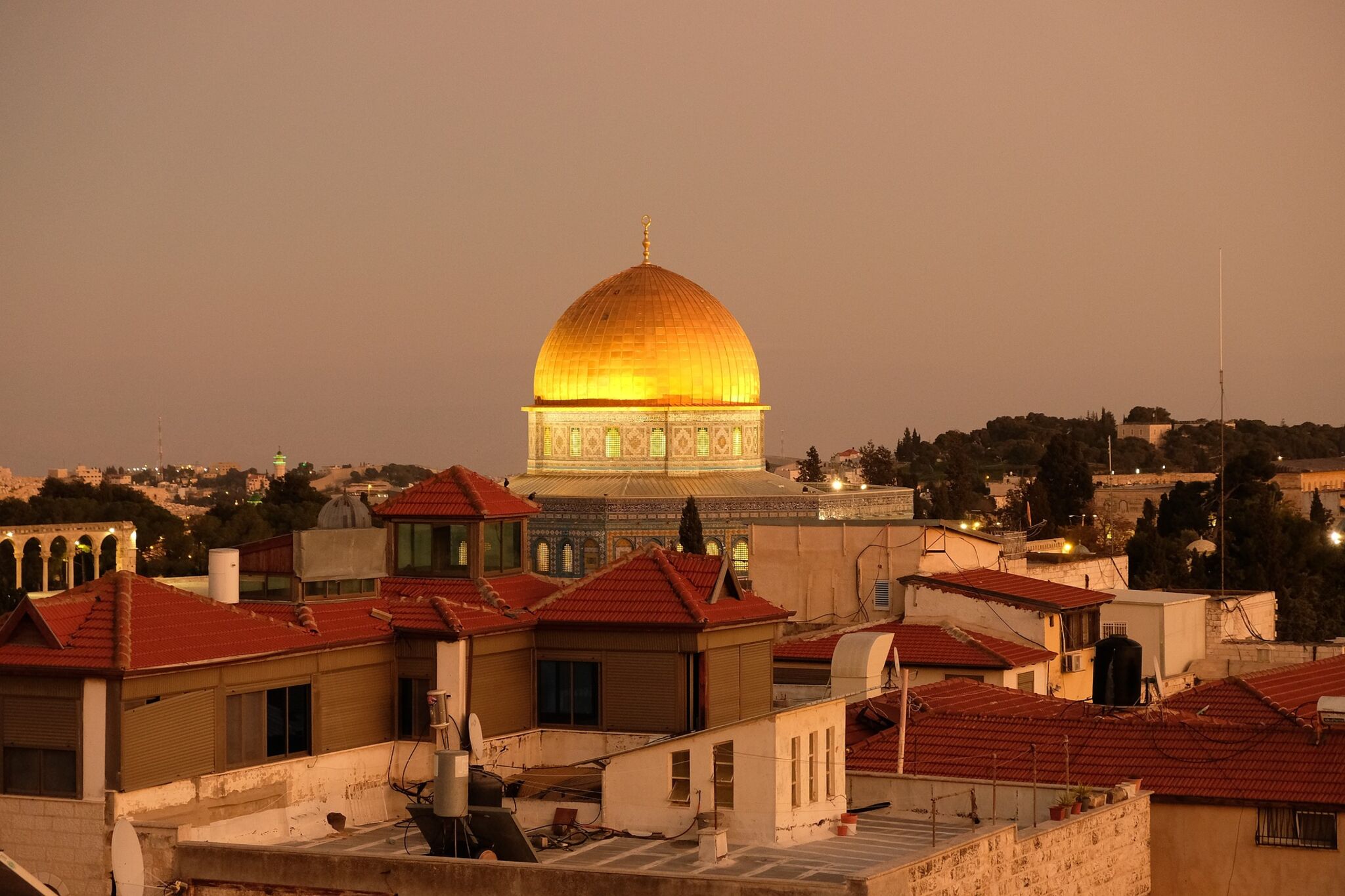 Das Bild zeigt den Felsendom in Jerusalem bei Sonnenuntergang. Seine Kuppel schimmert golden.