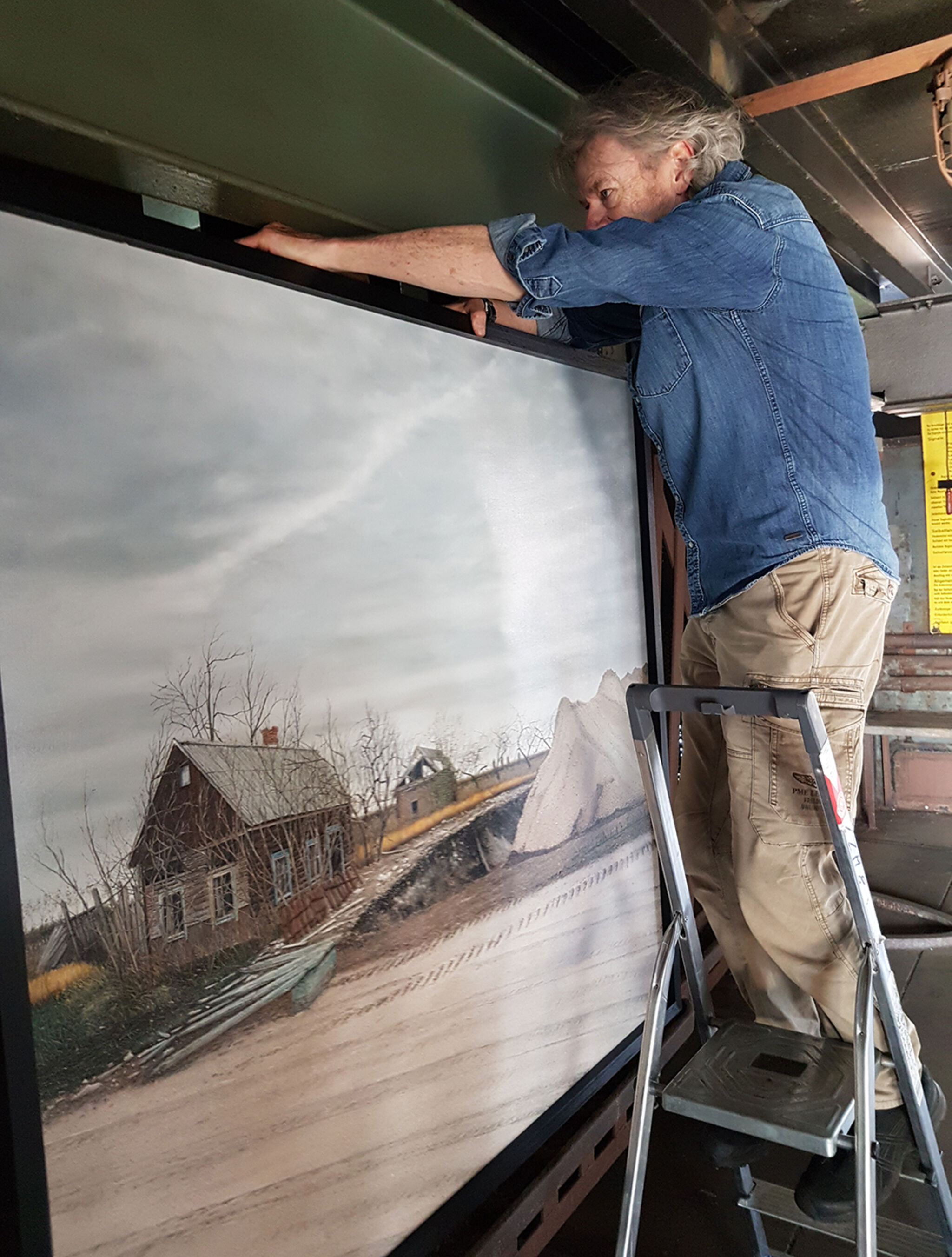 Tschernobyl Ausstellung_Hermann Buss haengt Bild auf