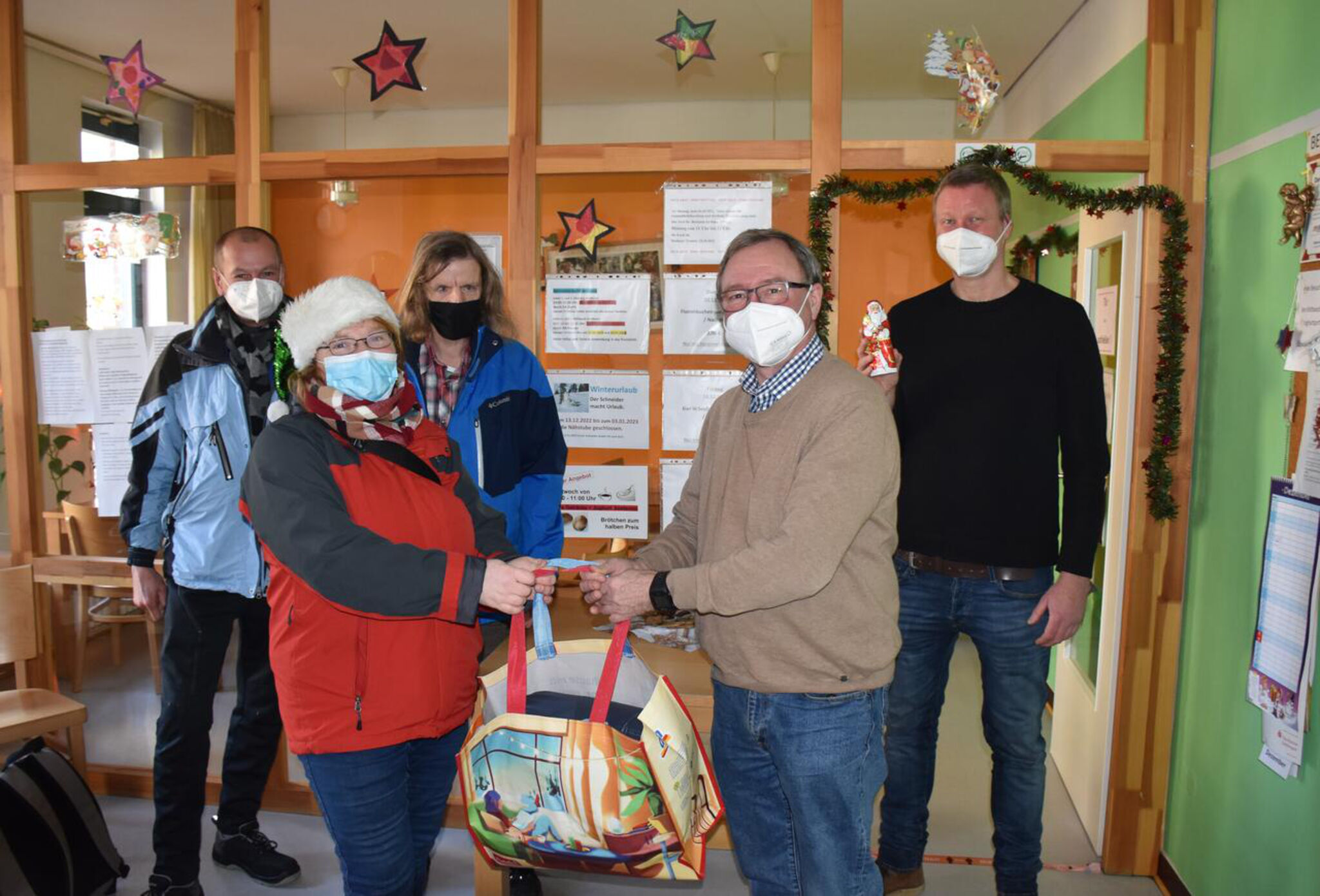 Frank, Constance und Rocky freuen sich über die Weihnachtstüte, übergeben von Arnold von Zepelin von der Johanniter-Hilfsgemeinschaft Göttingen und Straso-Leiter Mike Wacker