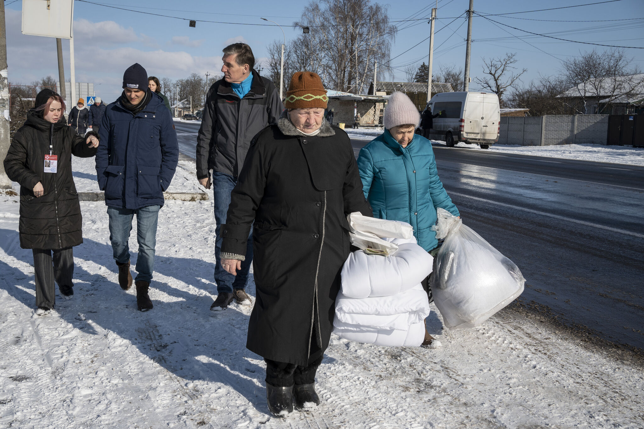 Martin Kessler (hinten Mitte), Direktor der Diakonie Katastrophenhilfe, und Mario Göb (hinten links), Programmkoordinator der Ukraine-Krise werden von der Mitarbeiterin einer Partnerorganisation über die Situation in Ivanivka, etwa zwei Autostunden nördlich von Kiew, informiert. Foto: Siegfried Modola/Diakonie Katastrophenhilfe