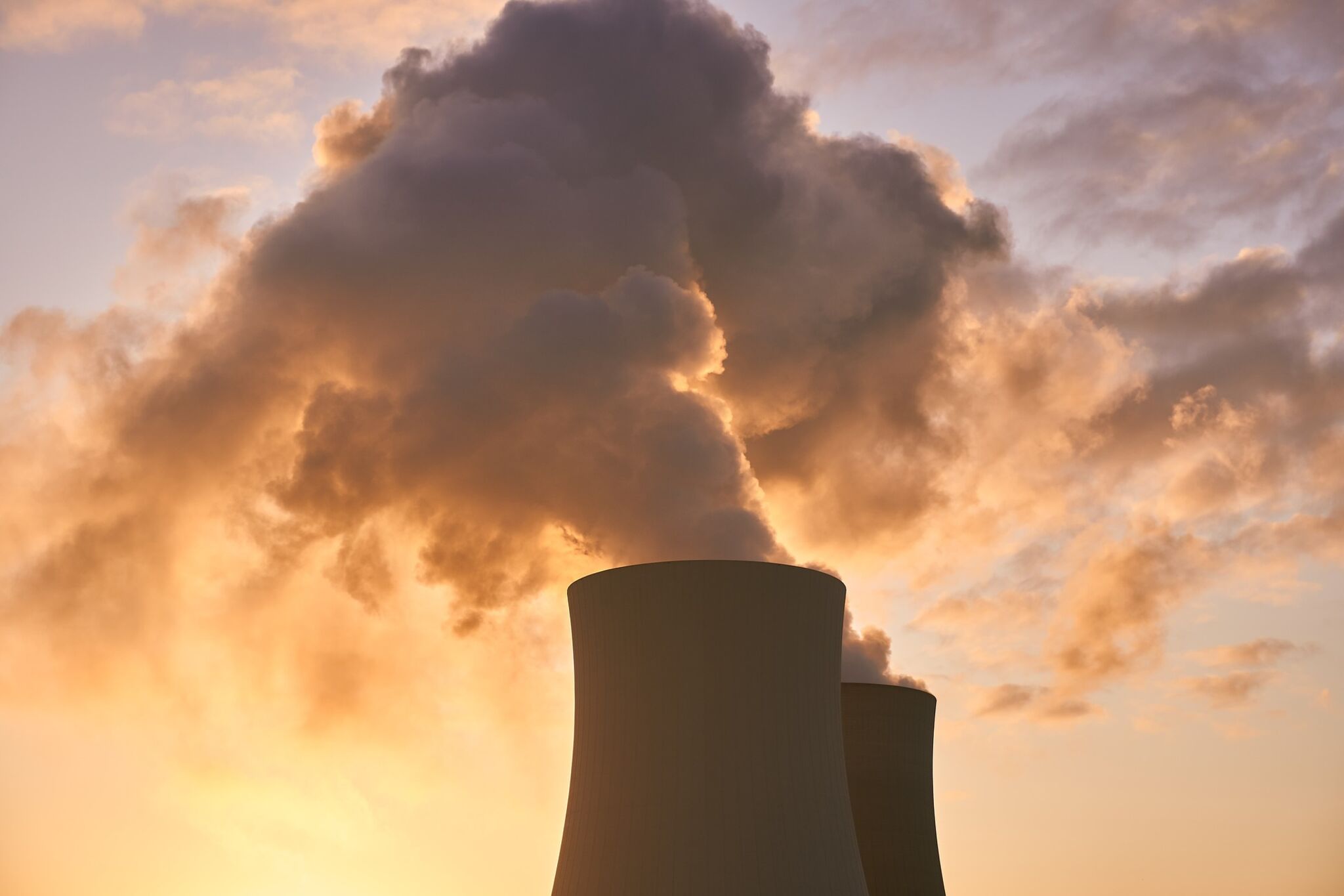 Auf dem Bild ist ein Kühlturm eines Atomkraftwerkes bei Sonnenuntergang zu sehen.