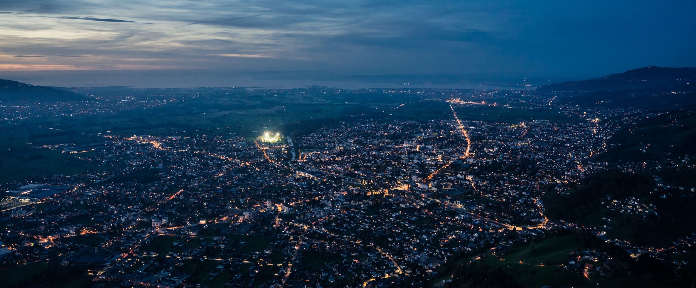 Luftaufnahme einer beleuchteten Stadt in der Abenddämmerung