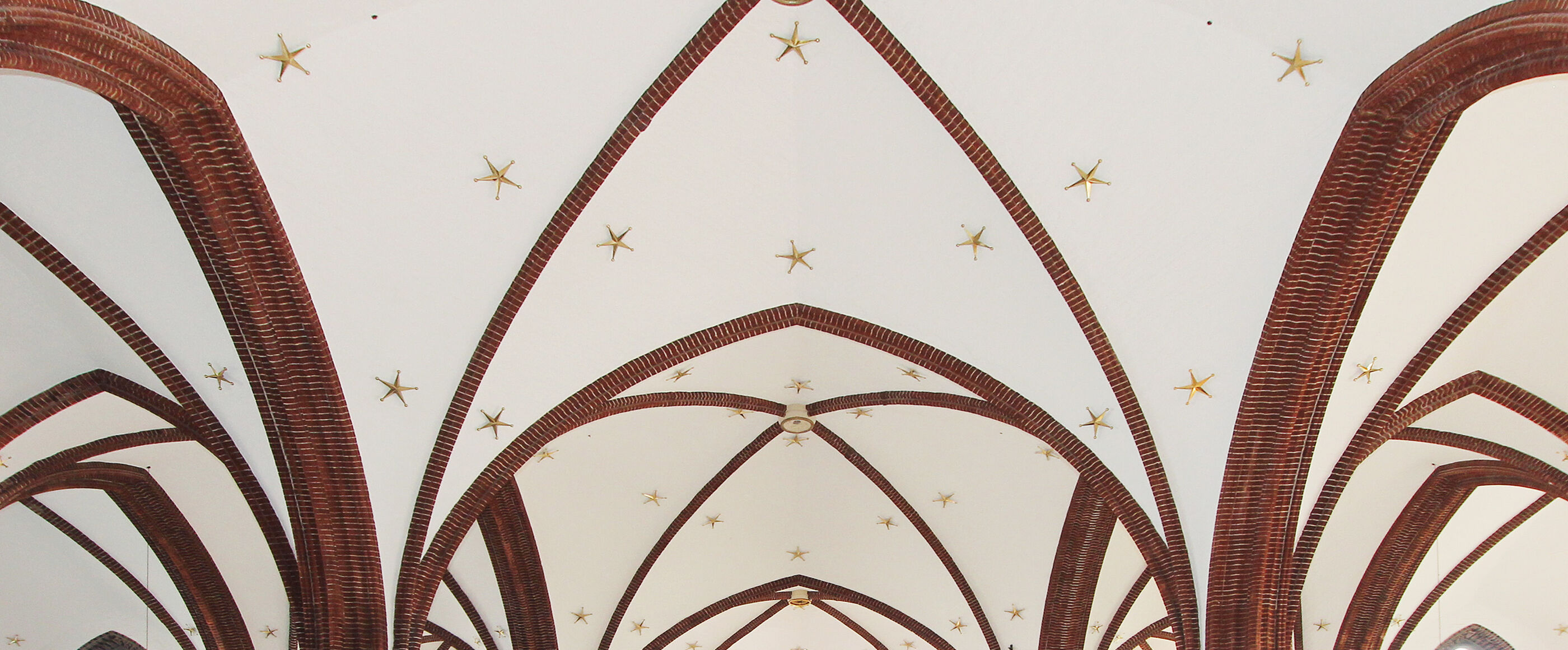 Eine mit Sternen verzierte Gewölbedecke in einer Kirche.