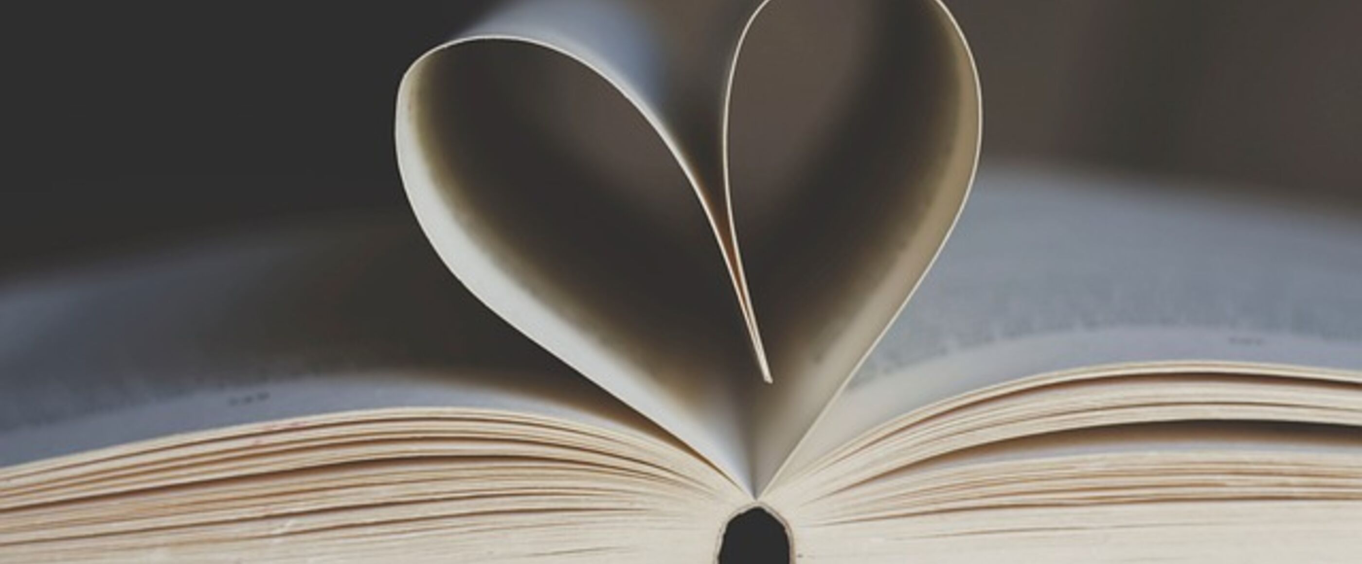 Ein aufgeschlagenes Buch. Zwei Seiten bilden eine Herzform