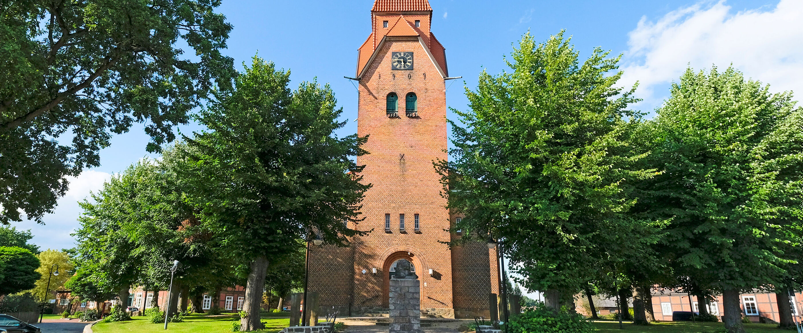 Ein Kirchturm, umgeben von Bäumen.