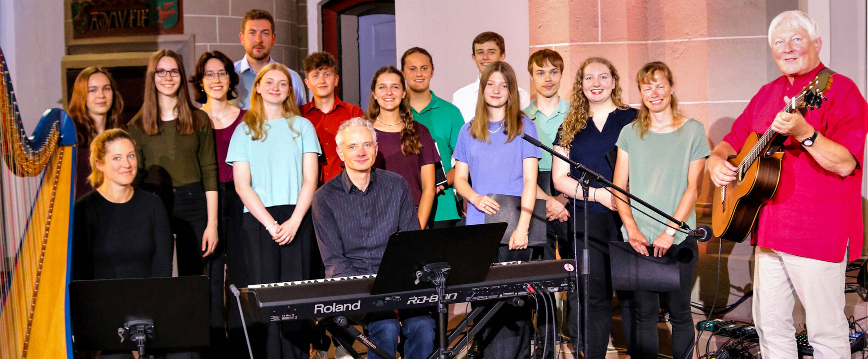 Ein Chor mit einer Harfenistin, einem Pianisten und einem Gitarristen.