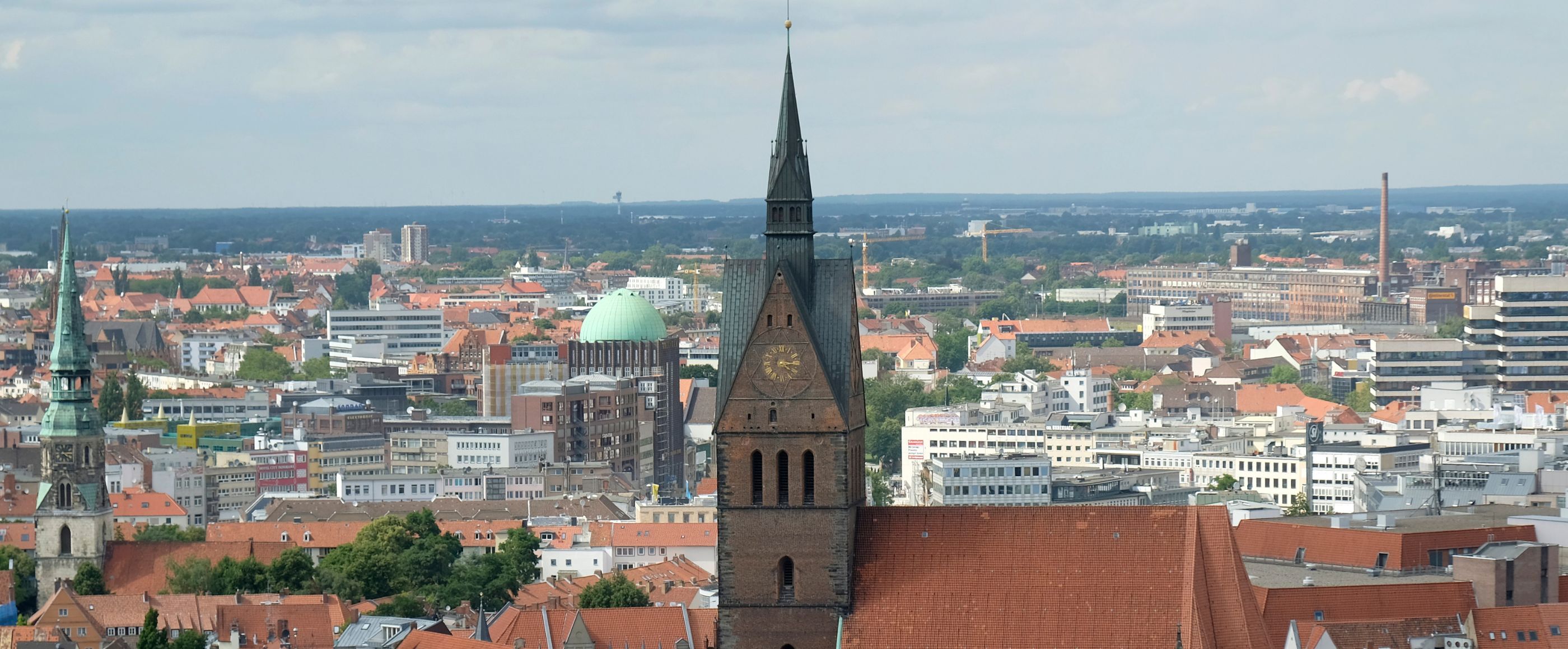 ein Kirchturm in einer Großstadt aus der Vogelperspektive fotografiert.